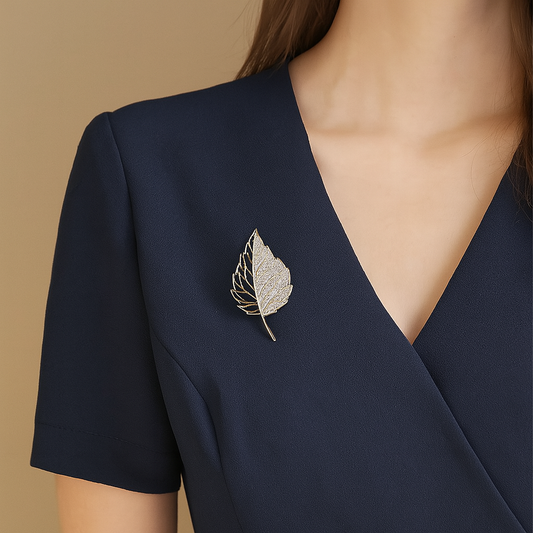 Half hollow leaf brooch in gold with sparkling stones
