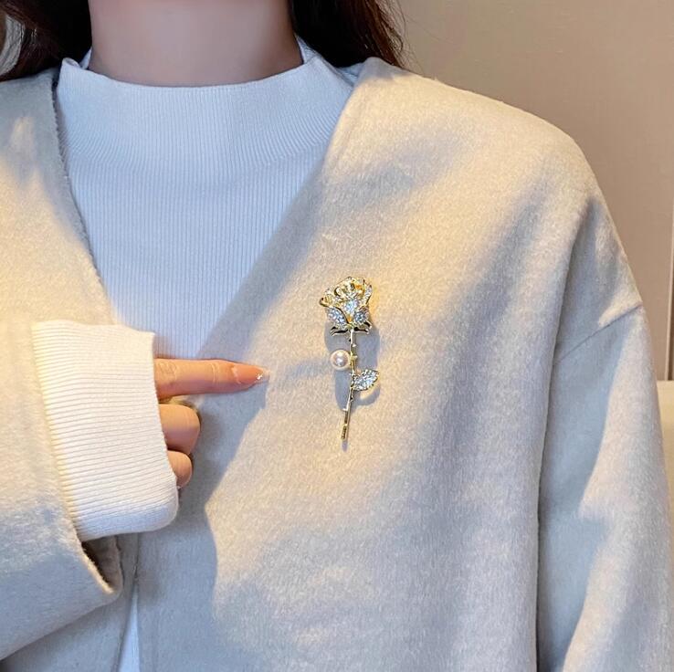 Elegant rose stem brooch in gold with crystals and pearl

