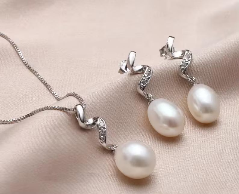 Silver and pearl jewelry set styled on neutral fabric for elegant presentation

