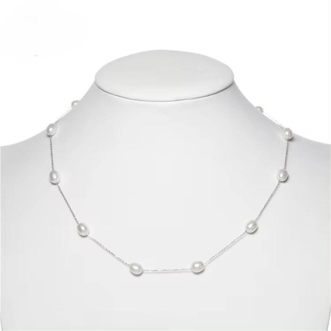 Elegant model in western attire showcasing floating pearl necklace with silver finish