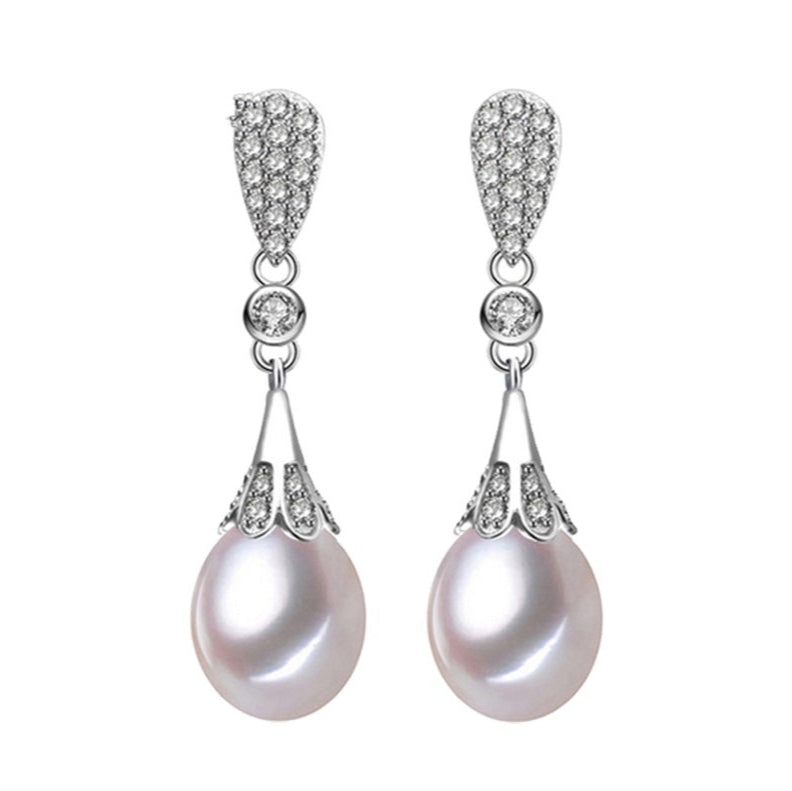 Close-up of handcrafted drop pearl earrings in silver