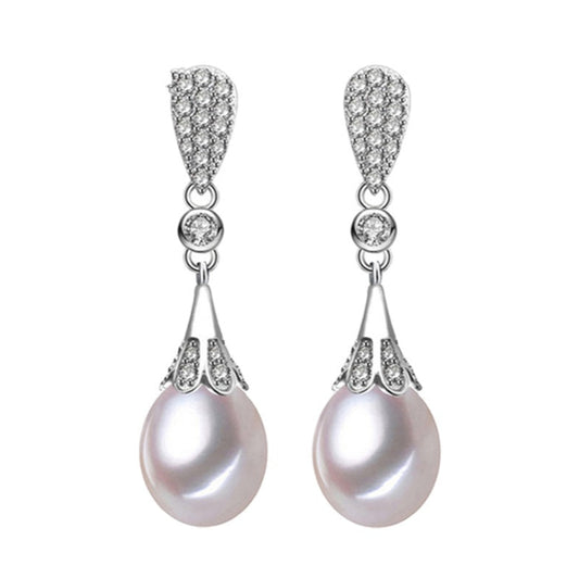 Close-up of handcrafted drop pearl earrings in silver