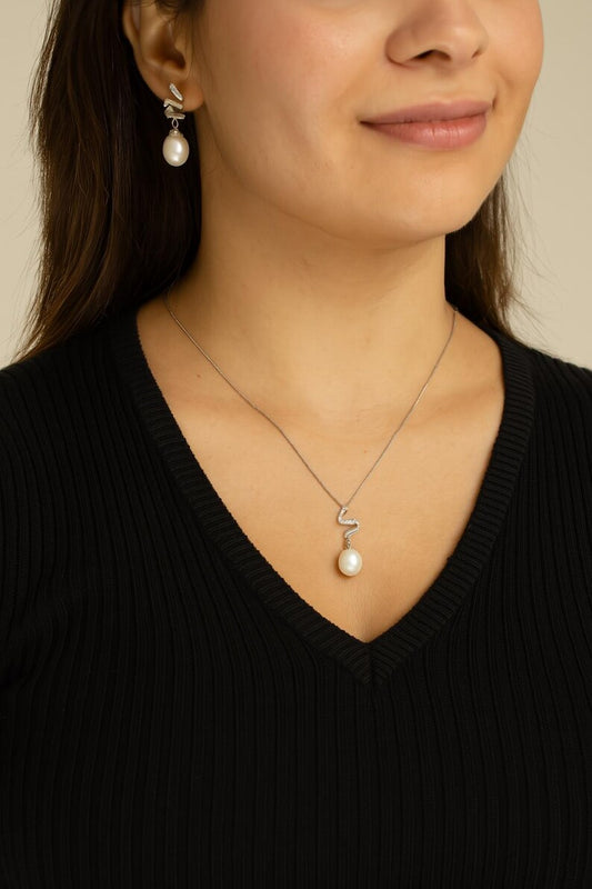 Woman wearing freshwater pearl necklace with twisted silver pendant, styled for a formal occasion



