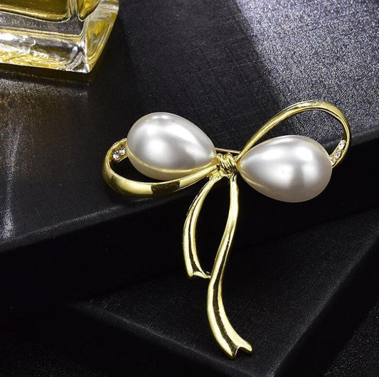 Stylish gold ribbon brooch with pearl drops


