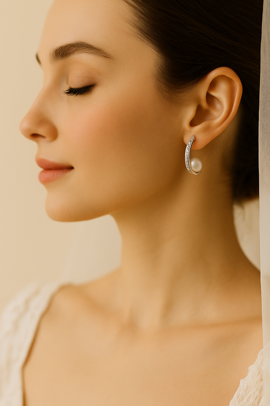 Bride wearing elegant pearl and zirconia silver earrings, styled with lace gown for wedding look

