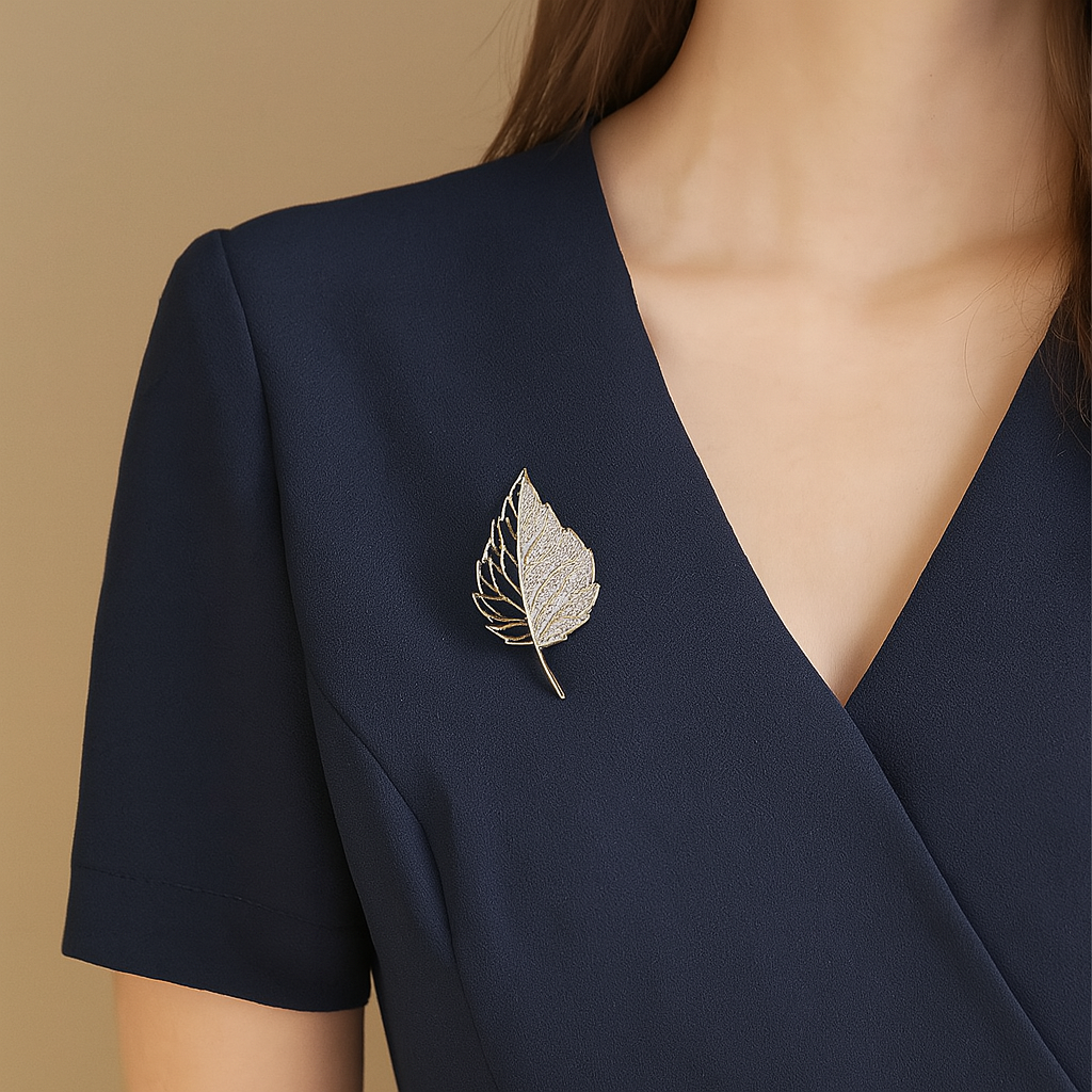 Half hollow leaf brooch in gold with sparkling stones

