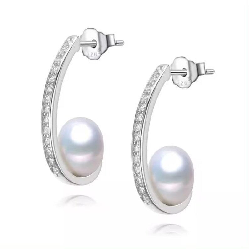 Minimalist sterling silver earrings with round freshwater pearl accent, modern curved design