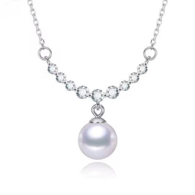 925 sterling silver necklace featuring a round freshwater pearl pendant and round-cut zircon stones in a graceful arc setting